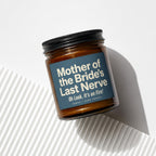 Amber candle with black lid reading "Mother of the Bride's Last Nerve Oh Look, It's on Fire!".