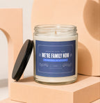 Glass candle with blue label reading "We're Family Now, Mom".