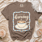 Brown t-shirt with "Love is Brewing" and a coffee cup graphic.