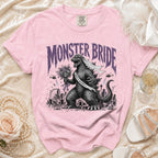 Pink t-shirt with "Monster Bride" print featuring Godzilla and city scape.