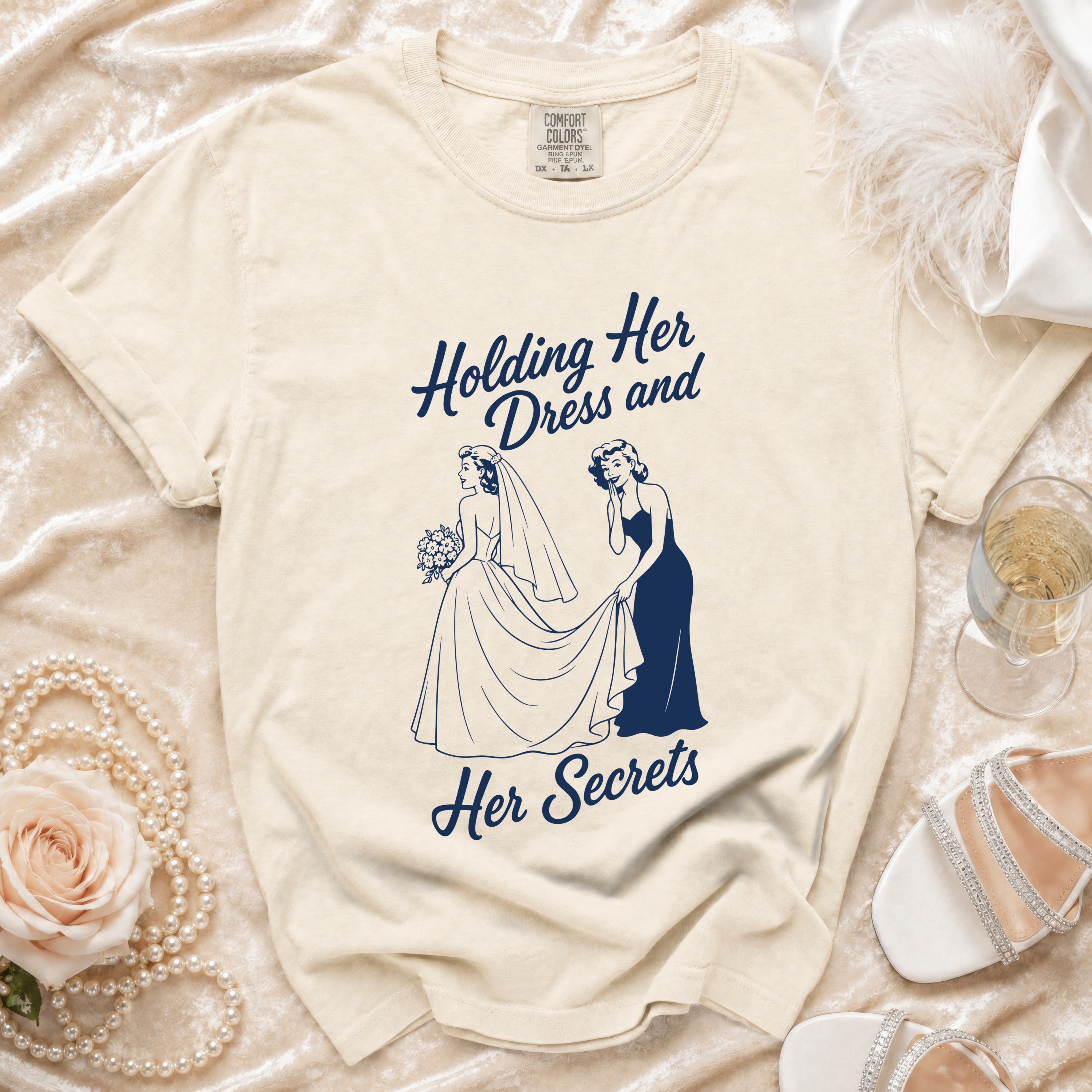 Cream t-shirt with "Holding Her Dress and Her Secrets" graphic of two women.