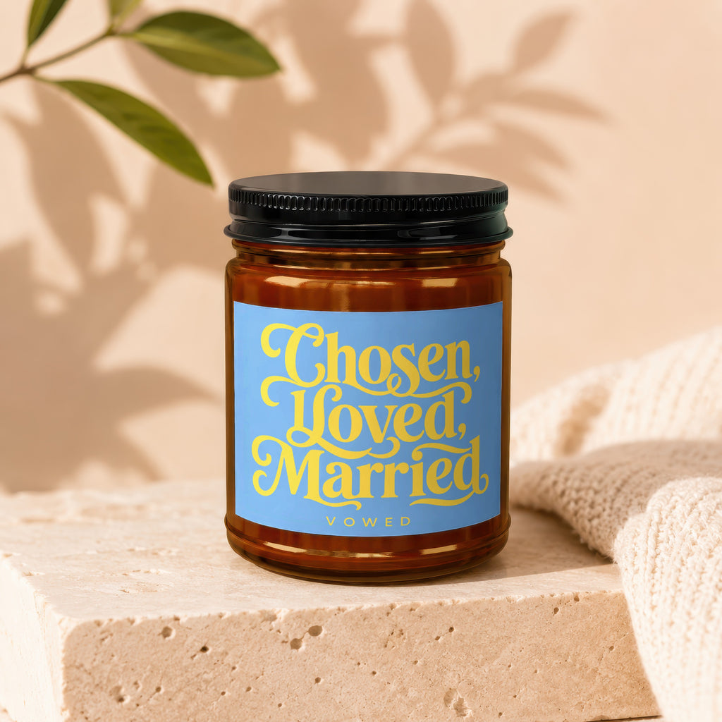 Amber candle in jar with blue label reading "Chosen, Loved, Married" and "Vowed".