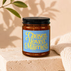 Amber candle in jar with blue label reading "Chosen, Loved, Married" and "Vowed".