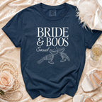 Navy blue t-shirt with "BRIDE & BOOS Social" and skeleton hands toasting champagne glasses.