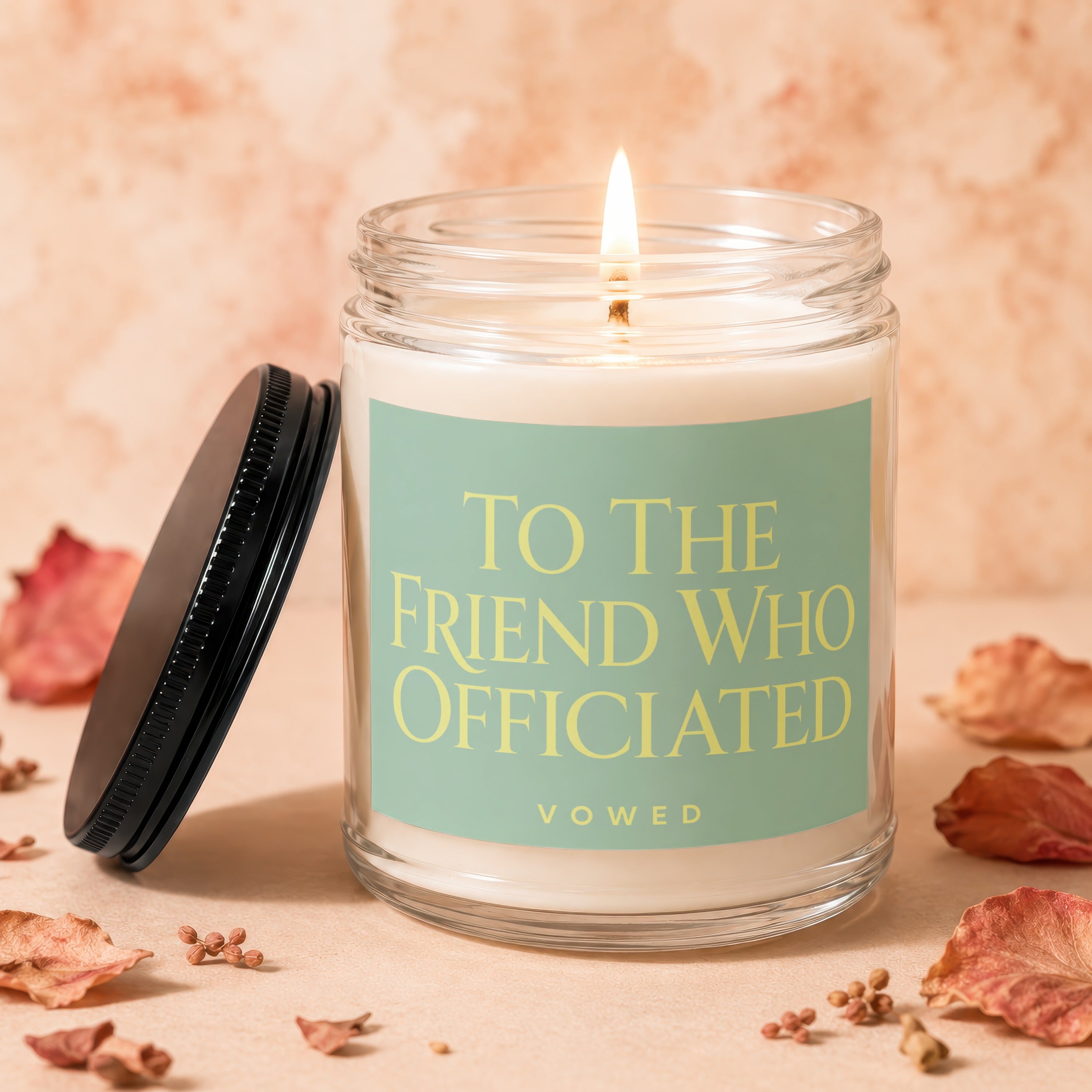 Lit candle in glass jar with text "TO THE FRIEND WHO OFFICIATED".