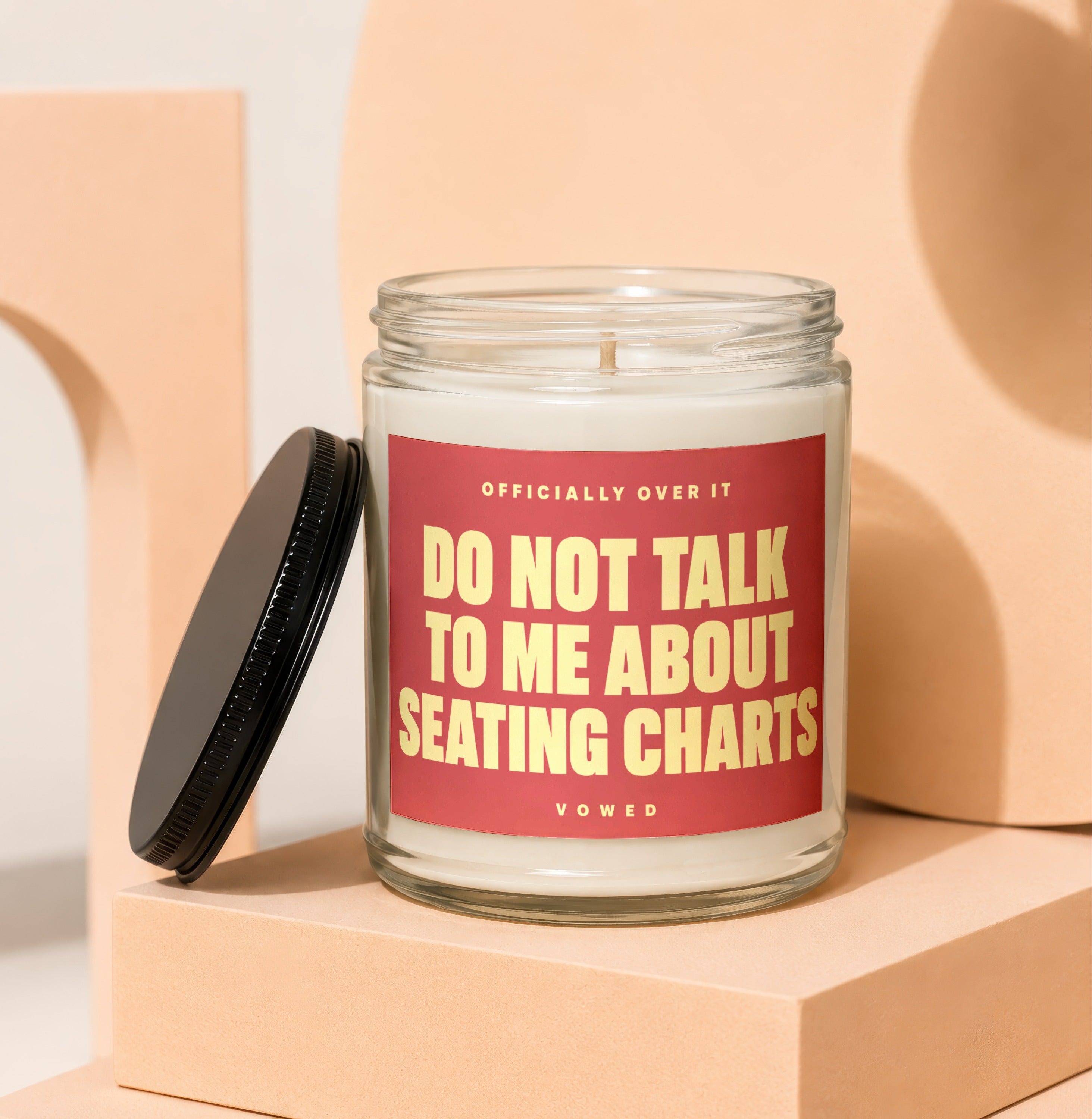 Glass candle with red label reading "DO NOT TALK TO ME ABOUT SEATING CHARTS".