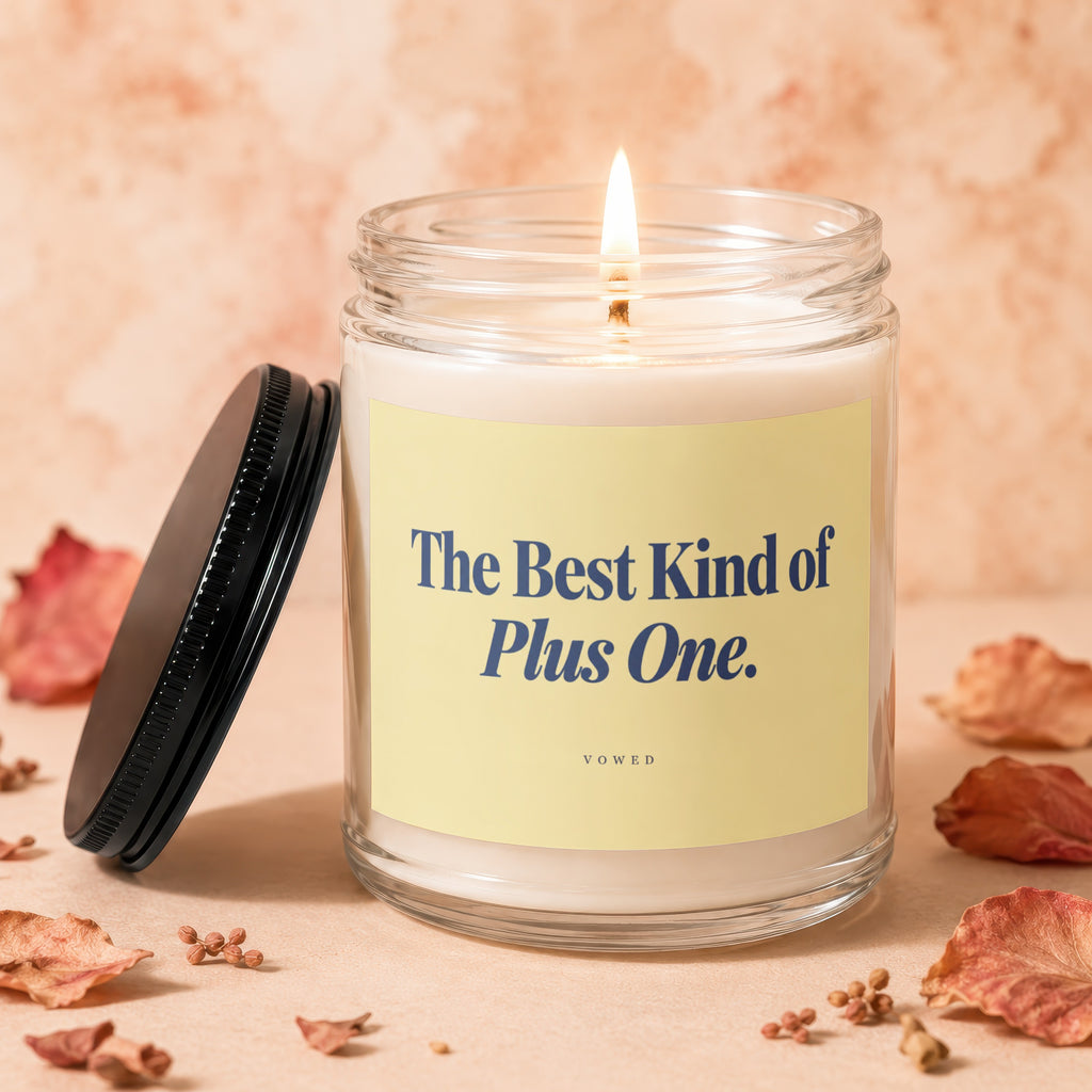 Lit candle in a glass jar with text "The Best Kind of Plus One. VOWED".