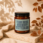 Amber candle with black lid, label reads "Team Bride Recruit Veteran Vowed."