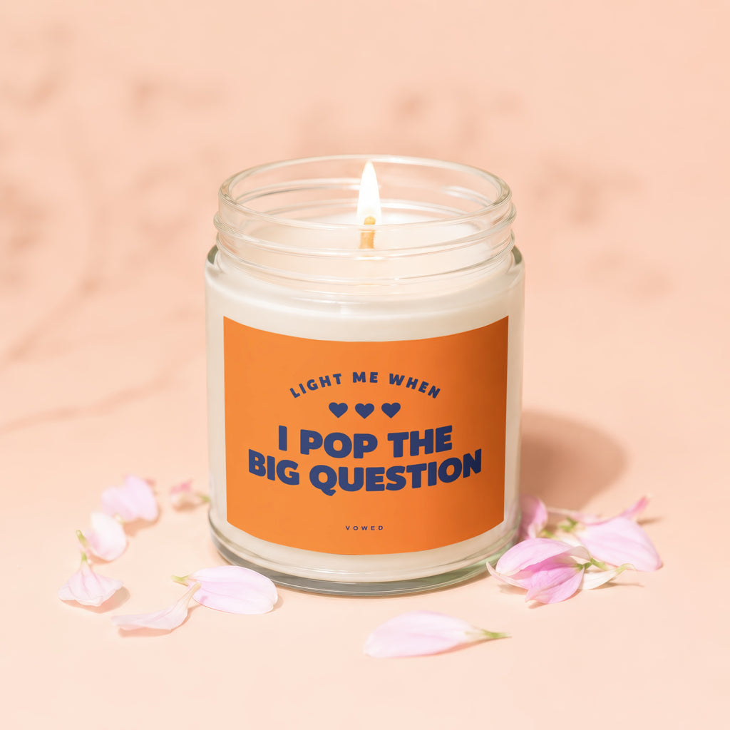 Candle with orange label that reads "Light me when I pop the big question".