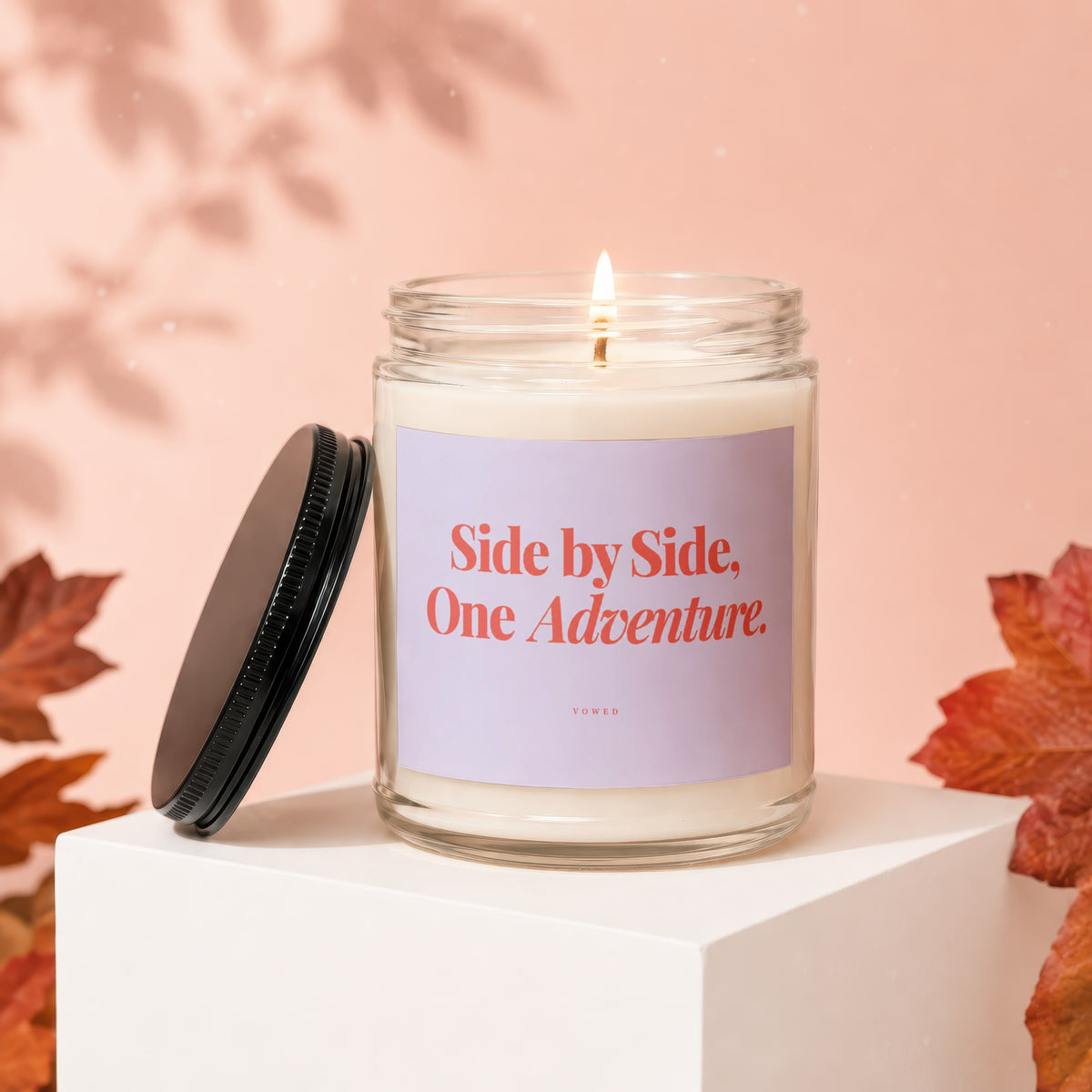 Lit candle in glass jar with text "Side by Side, One Adventure." and "VOWED".