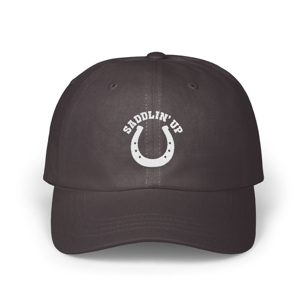 Dark gray baseball cap with an embroidered white horseshoe design and the text SADDLIN UP.