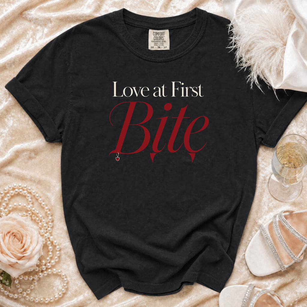 Black t-shirt with "Love at First Bite" text, small apple pendant.