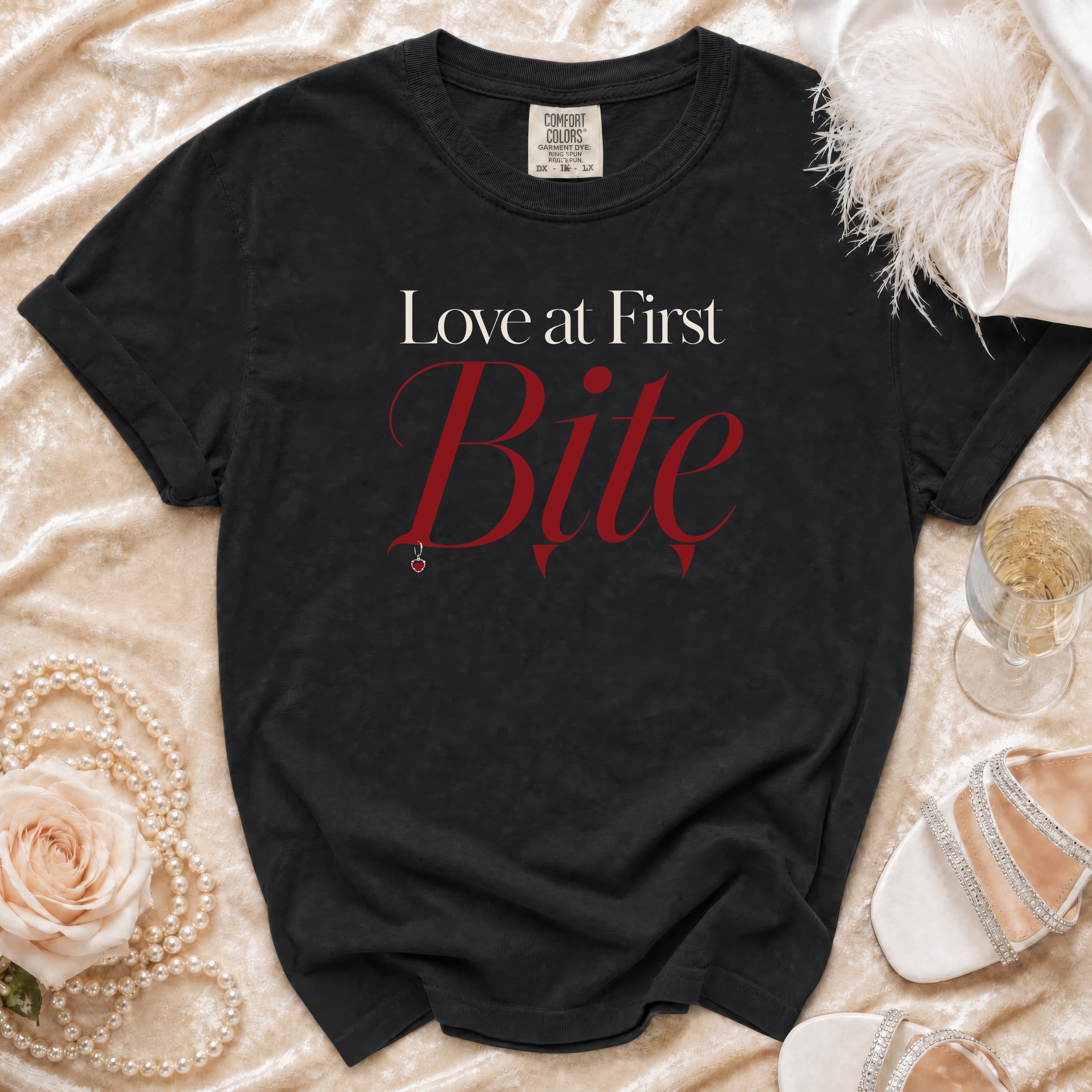 Black t-shirt with "Love at First Bite" text, small apple pendant.