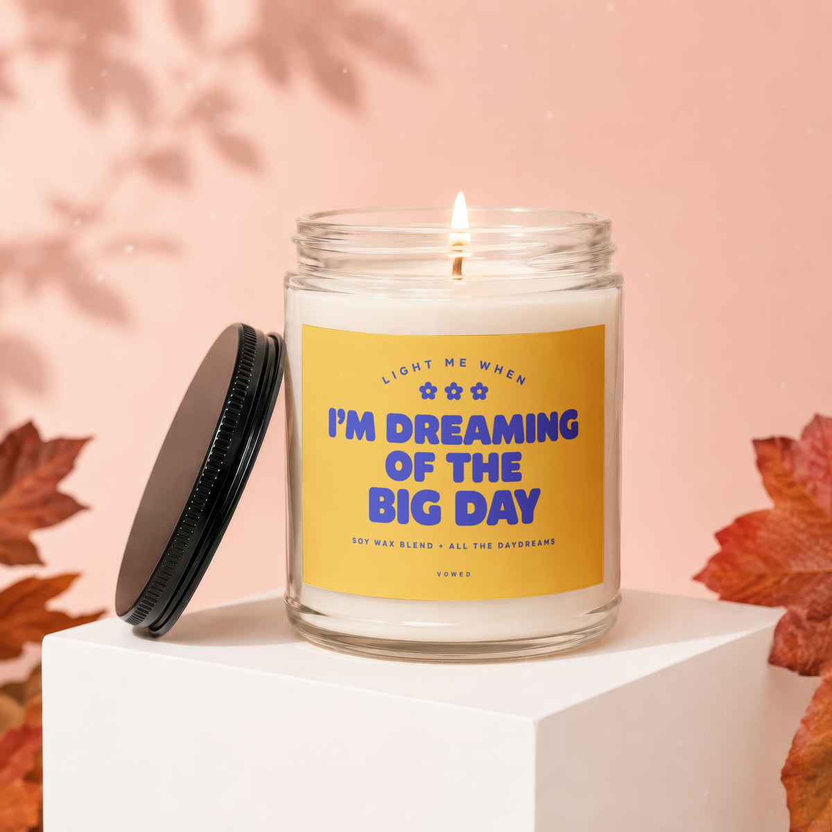 Jar candle with lit wick, featuring yellow label with blue text "I'M DREAMING OF THE BIG DAY".
