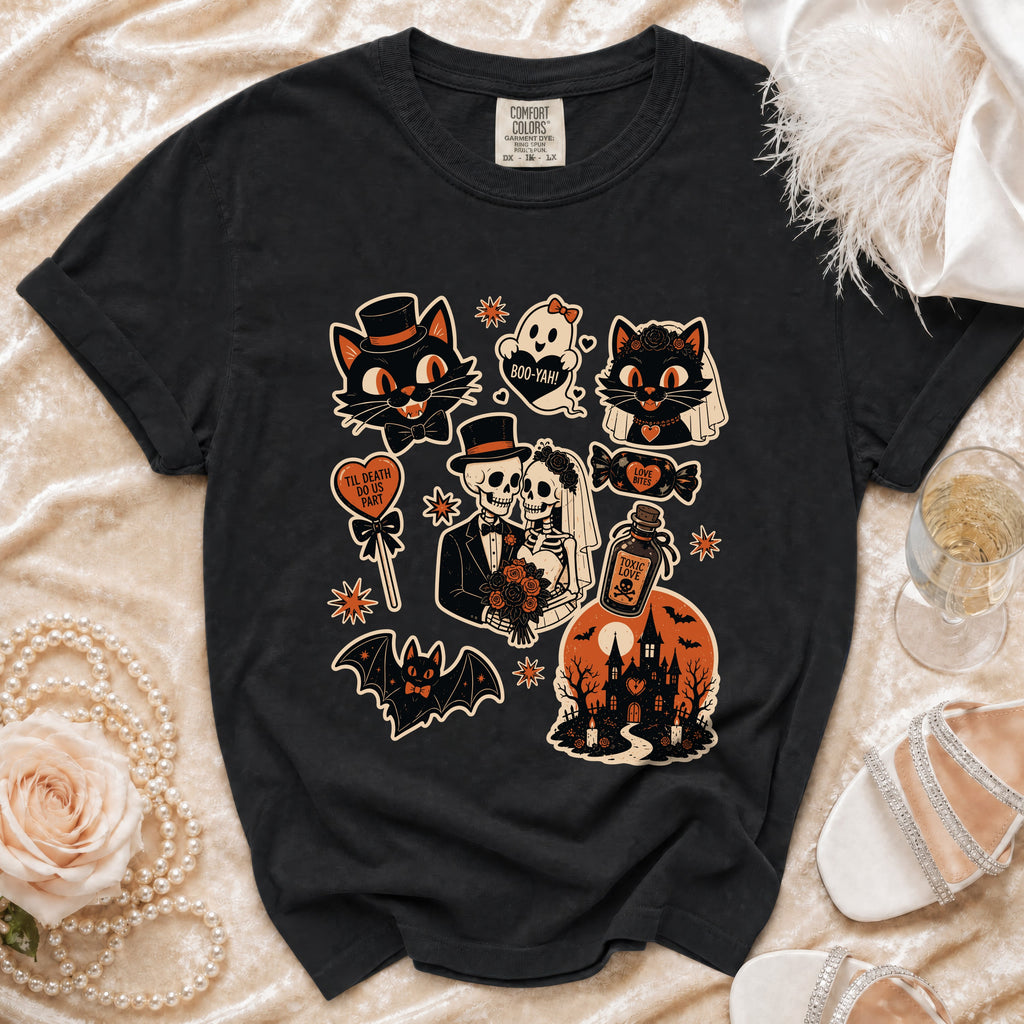 Black t-shirt with various Halloween-themed graphic stickers including cats, skeletons, and a haunted house.