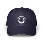 A dark blue baseball cap with white embroidery featuring a horseshoe and the text SADDLIN' UP.
