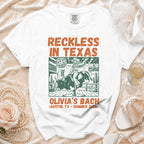 White t-shirt with "Reckless in Texas" and bull rider graphic.