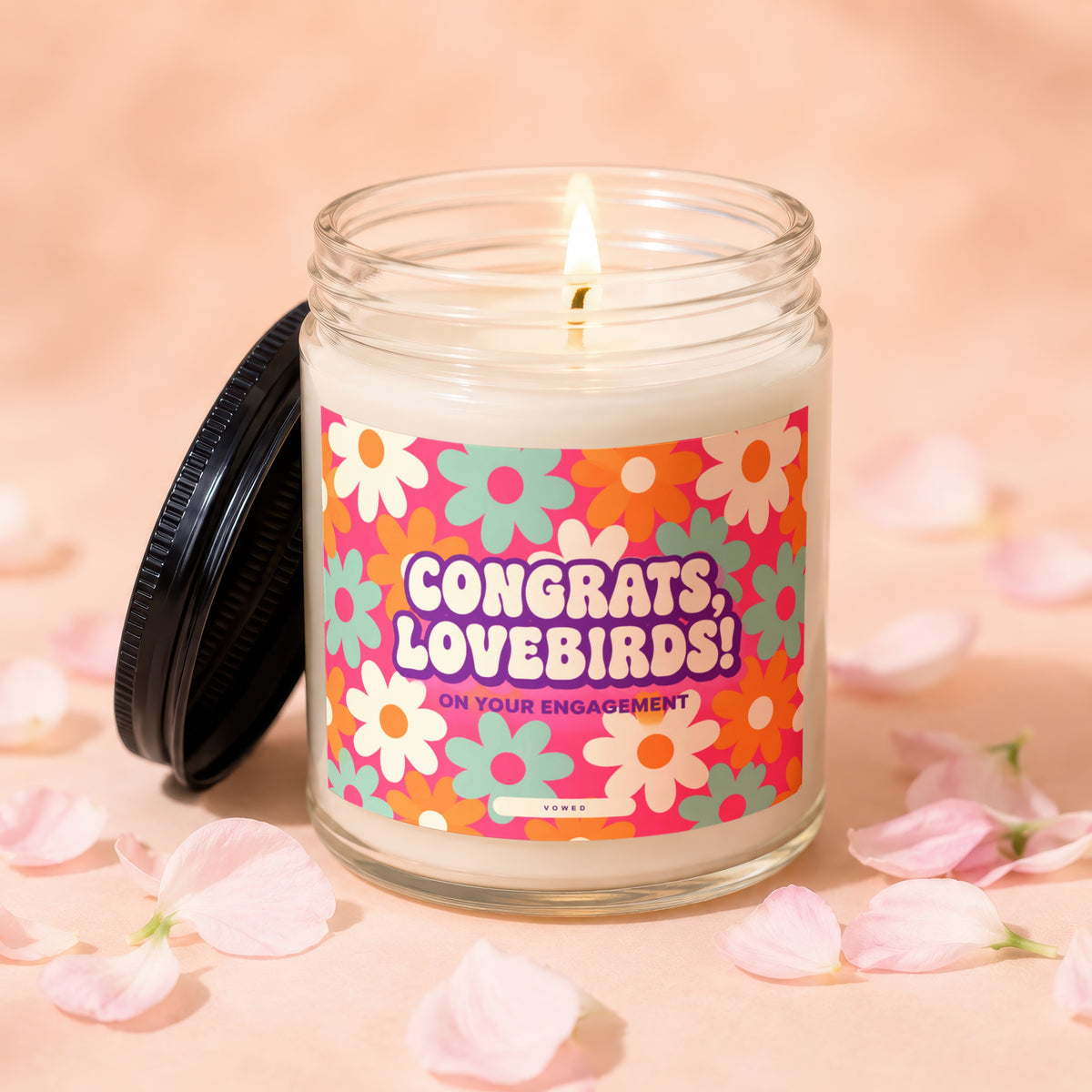 Candle with a retro floral label reading "Congrats, Lovebirds! On Your Engagement."