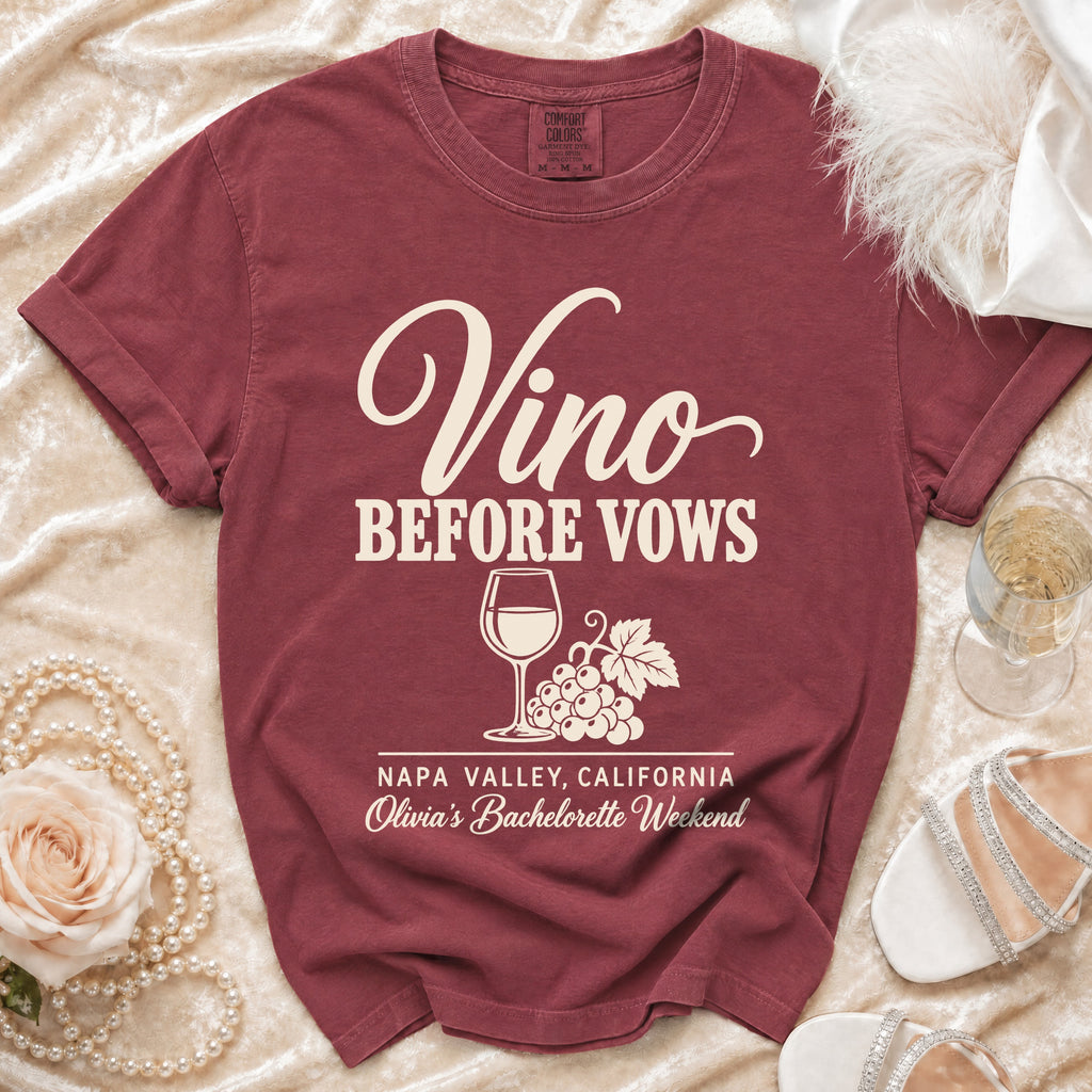 Maroon t-shirt with cream text reading "Vino BEFORE VOWS," a wine glass, grapes, and "Napa Valley, California."