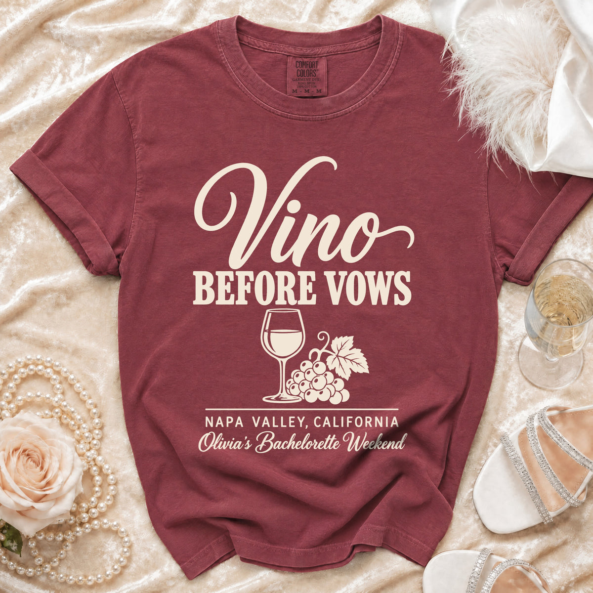 Maroon t-shirt with cream text reading "Vino BEFORE VOWS," a wine glass, grapes, and "Napa Valley, California."