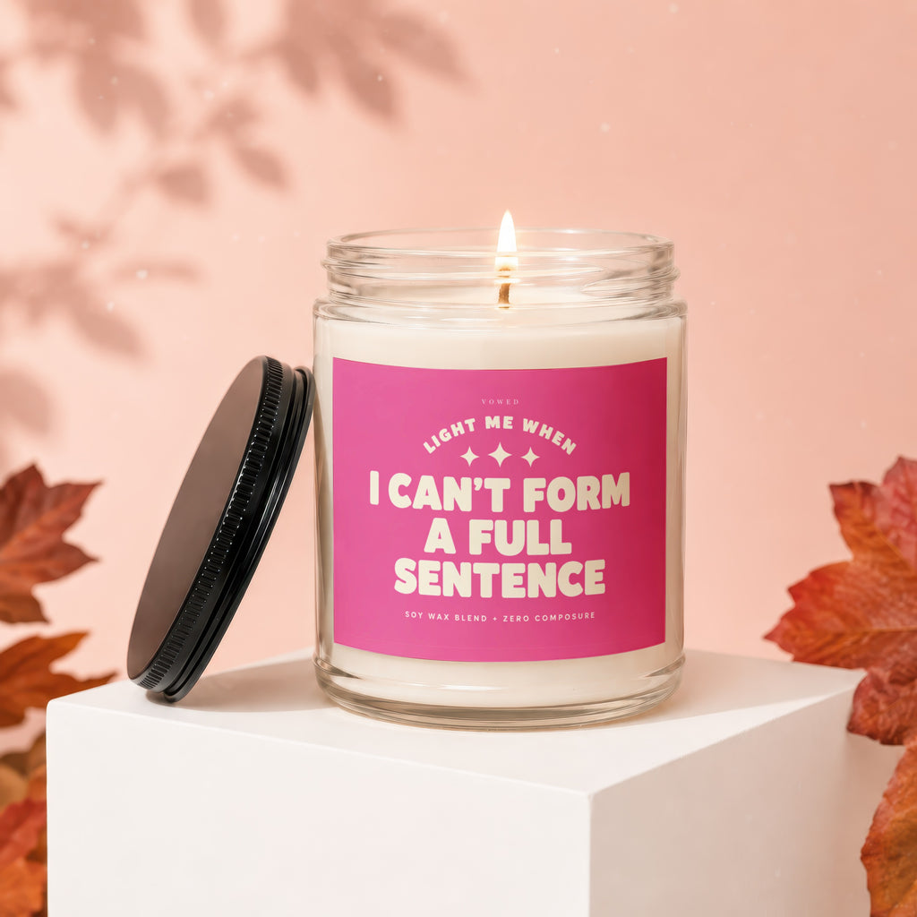 Jar candle with pink label reading "Light Me When I Can't Form A Full Sentence."