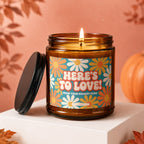 Amber candle with "Here's to Love! From Your Biggest Fans" on a floral label.