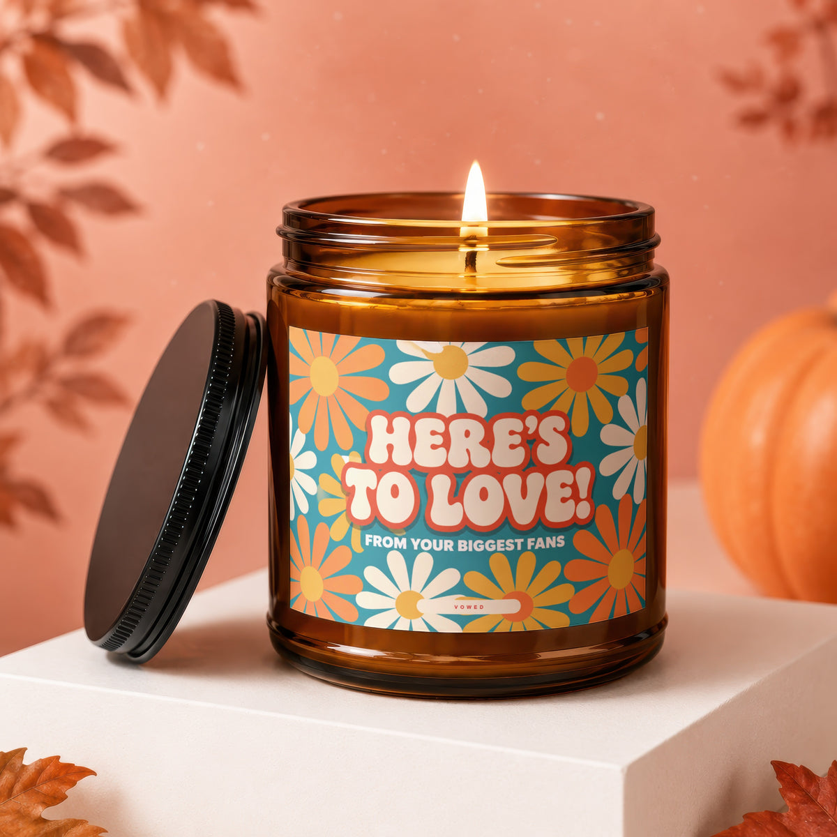 Amber candle with "Here's to Love! From Your Biggest Fans" on a floral label.