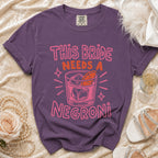 Purple t-shirt with pink text "This Bride Needs a Negroni" and a cocktail illustration.