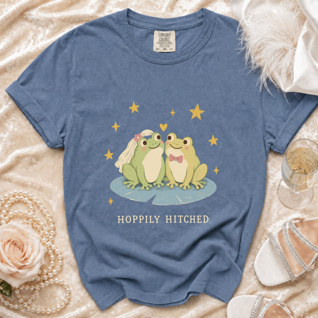 Blue t-shirt with graphic of two frogs, stars, and text "Hoppily Hitched".