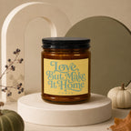 Amber jar candle with yellow label reading "Love, But Make It Home" and "vowed".