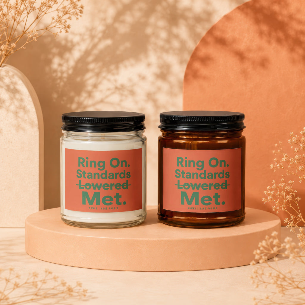 Two candles with text "Ring On. Standards Lowered Met." on coral labels.