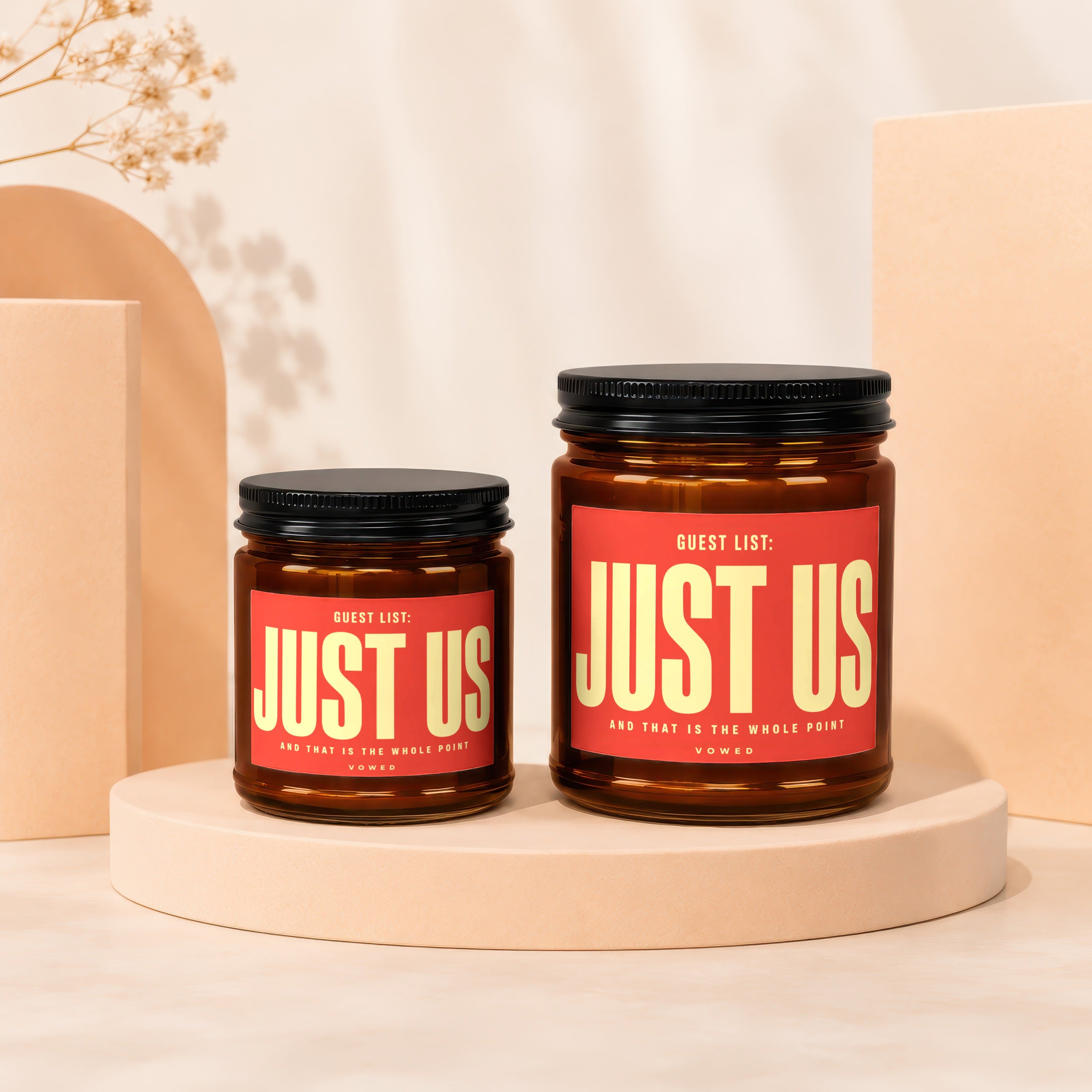 Two amber glass candles with "JUST US" on red labels.
