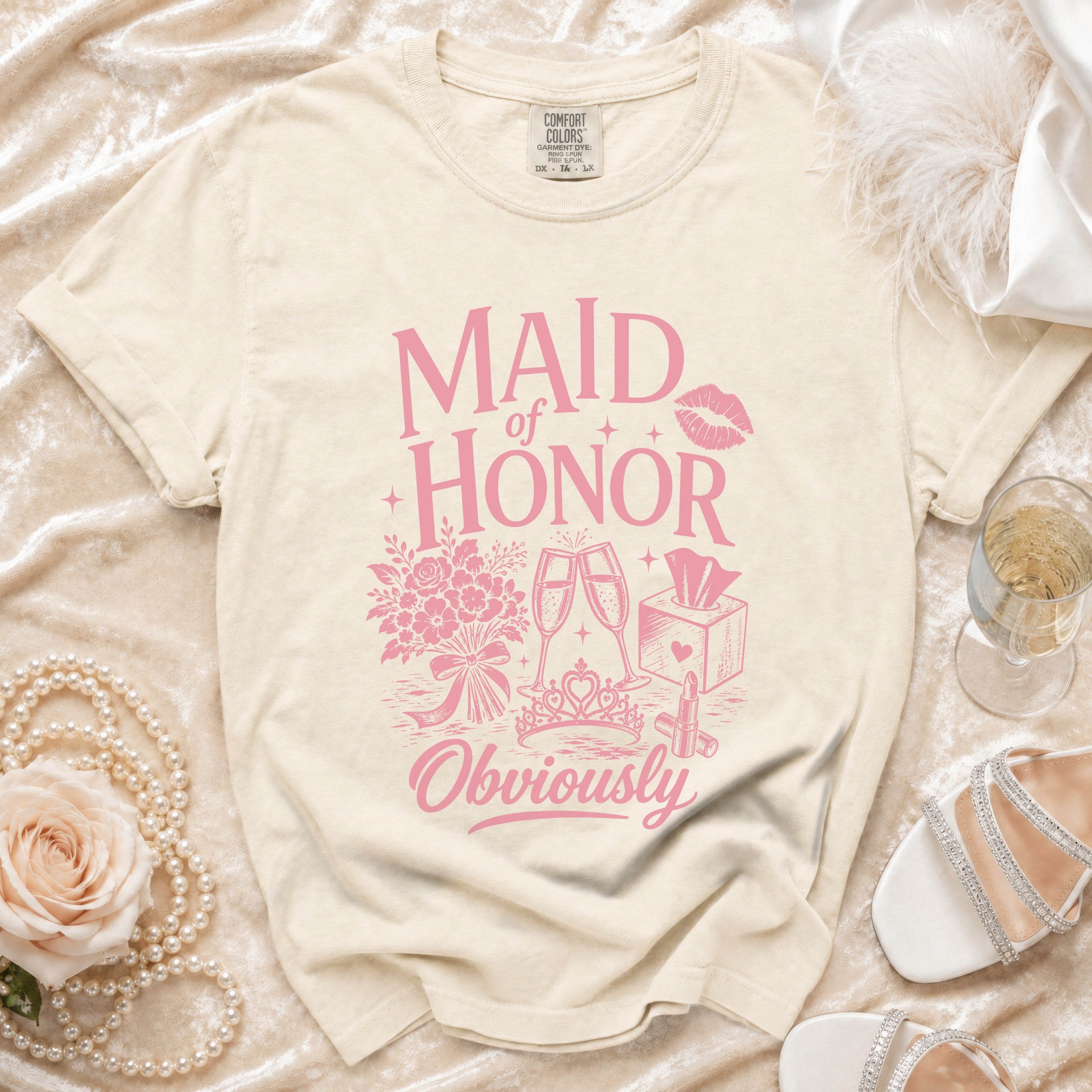 Light beige t-shirt with pink "Maid of Honor Obviously" graphic and wedding icons.