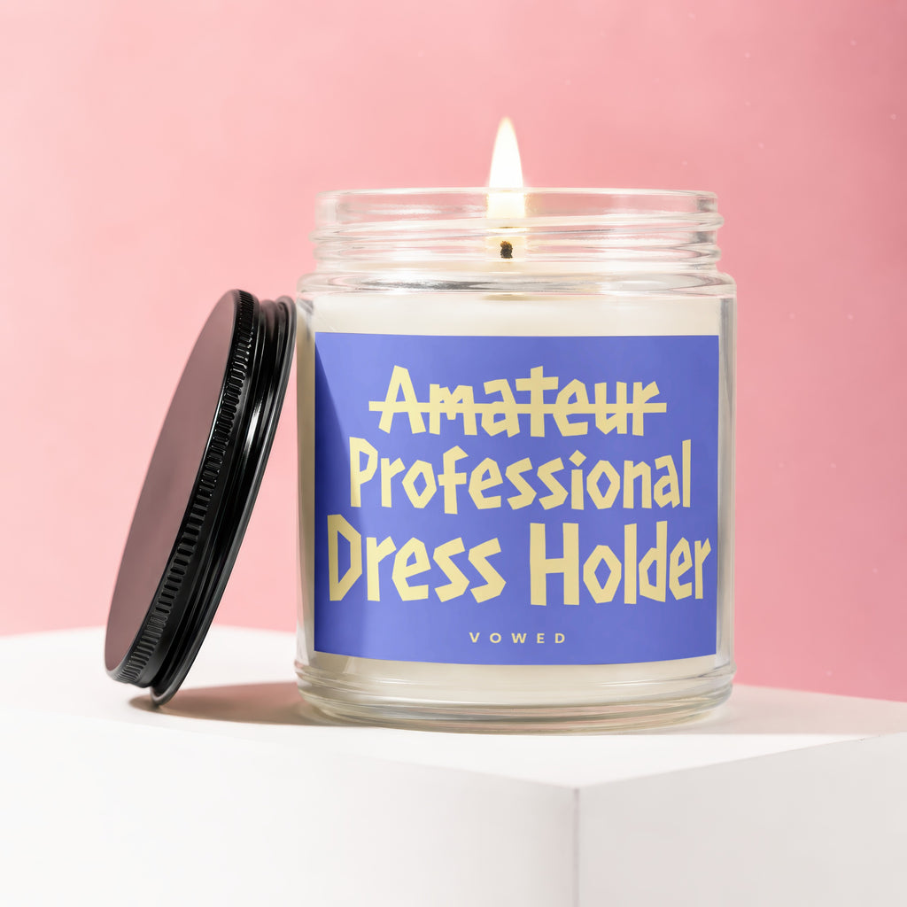 Candle with blue label reading "Amateur Professional Dress Holder VOWED".