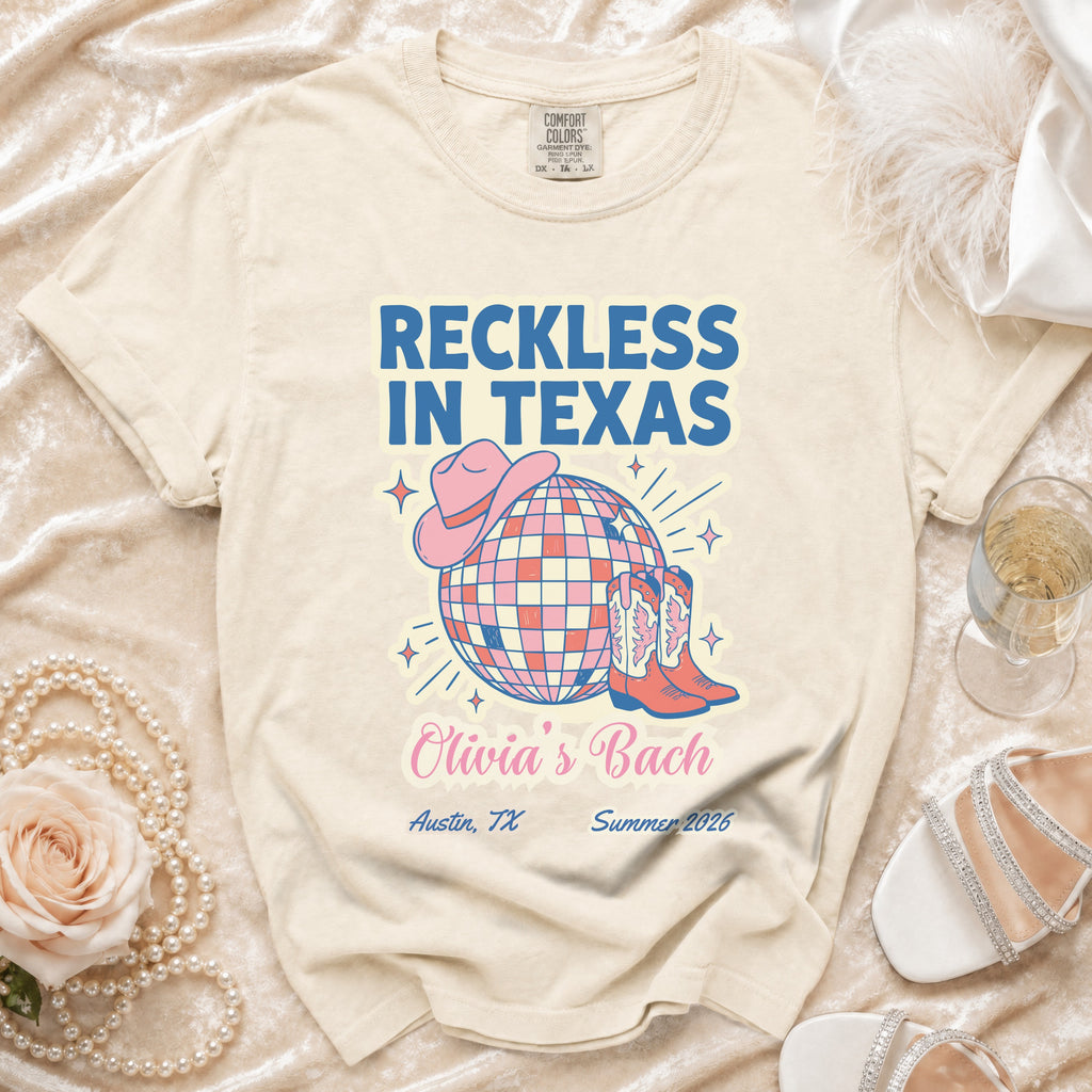 Cream t-shirt with "Reckless in Texas" and "Olivia's Bach" text, cowboy boots, and hat.
