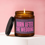 Brown glass candle with a lit wick and dark lid, reads "Burn After The Wedding".
