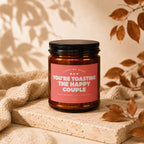 Amber jar candle with pink label that reads "You're Toasting the Happy Couple."