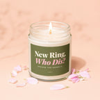 Candle with lit wick and green label reading "New Ring, Who Dis?"