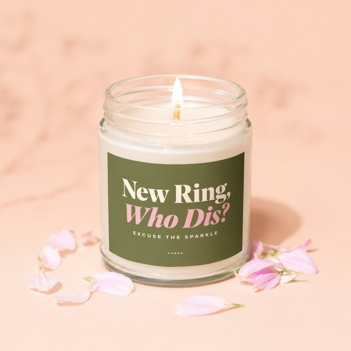 Candle with lit wick and green label reading "New Ring, Who Dis?"