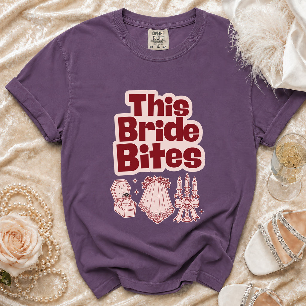 Purple t-shirt with "This Bride Bites" graphic and wedding-themed icons.