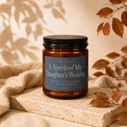 Amber glass candle with text "I Survived My Daughter's Wedding".