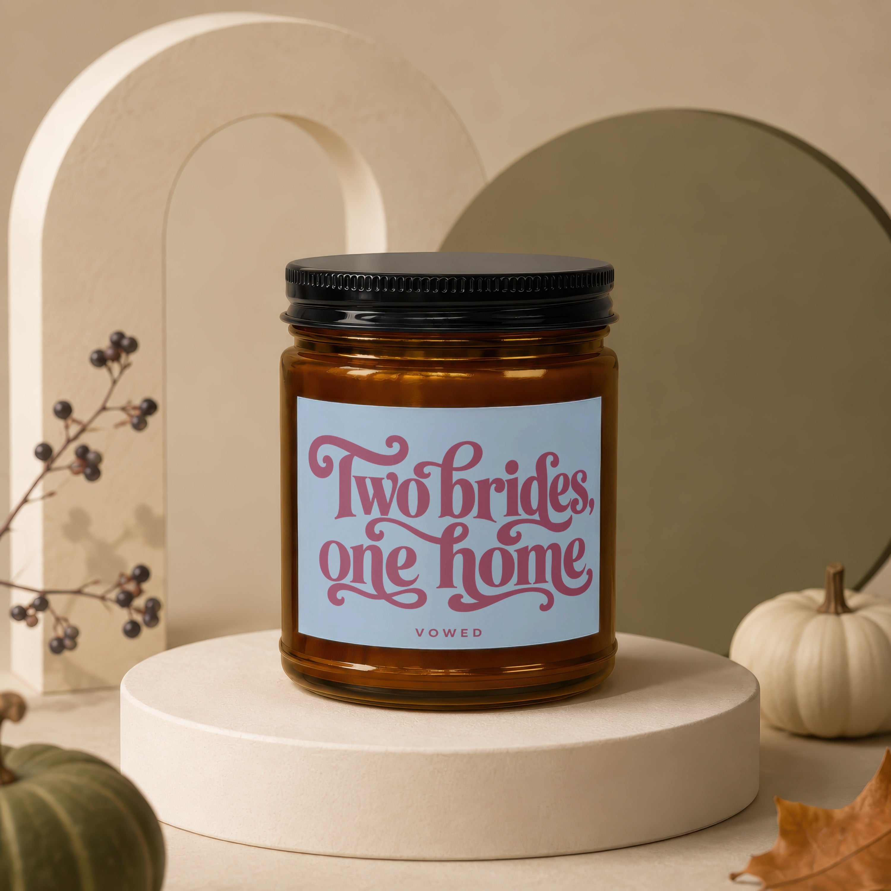 Amber candle with black lid and "Two brides, one home VOWED" label.
