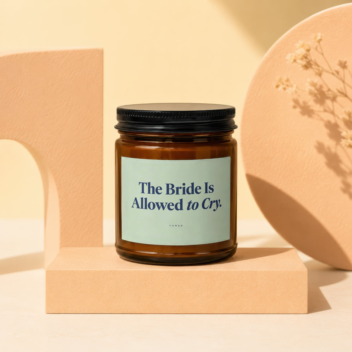 Amber candle with black lid, labeled "The Bride Is Allowed to Cry."