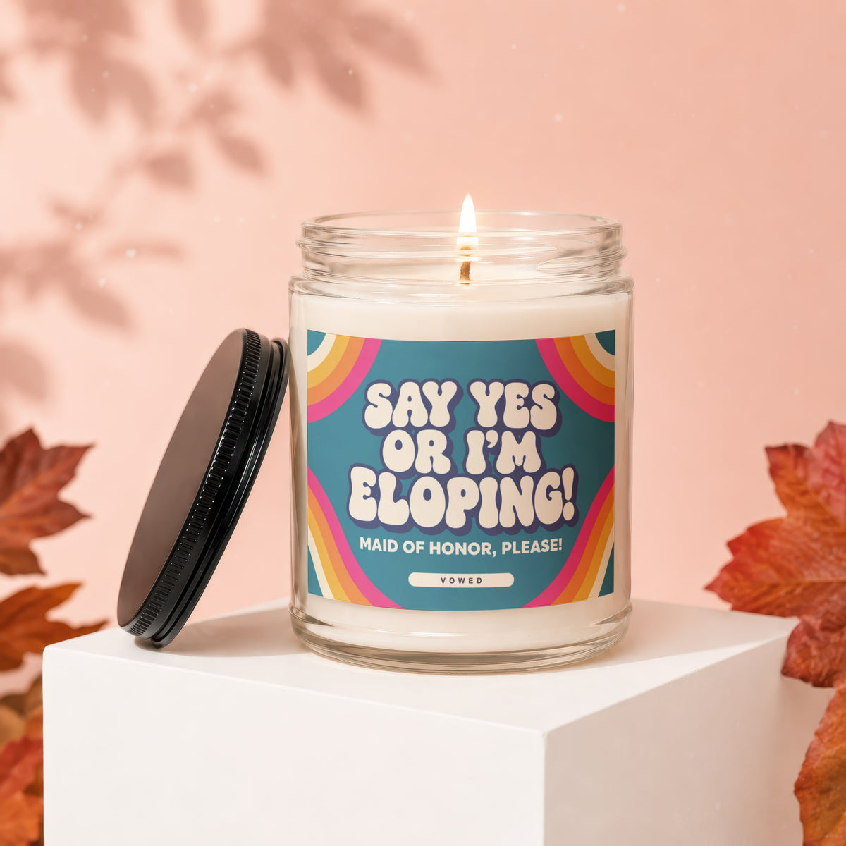 Candle with "Say Yes or I'm Eloping! Maid of Honor, Please!" text on a retro label.