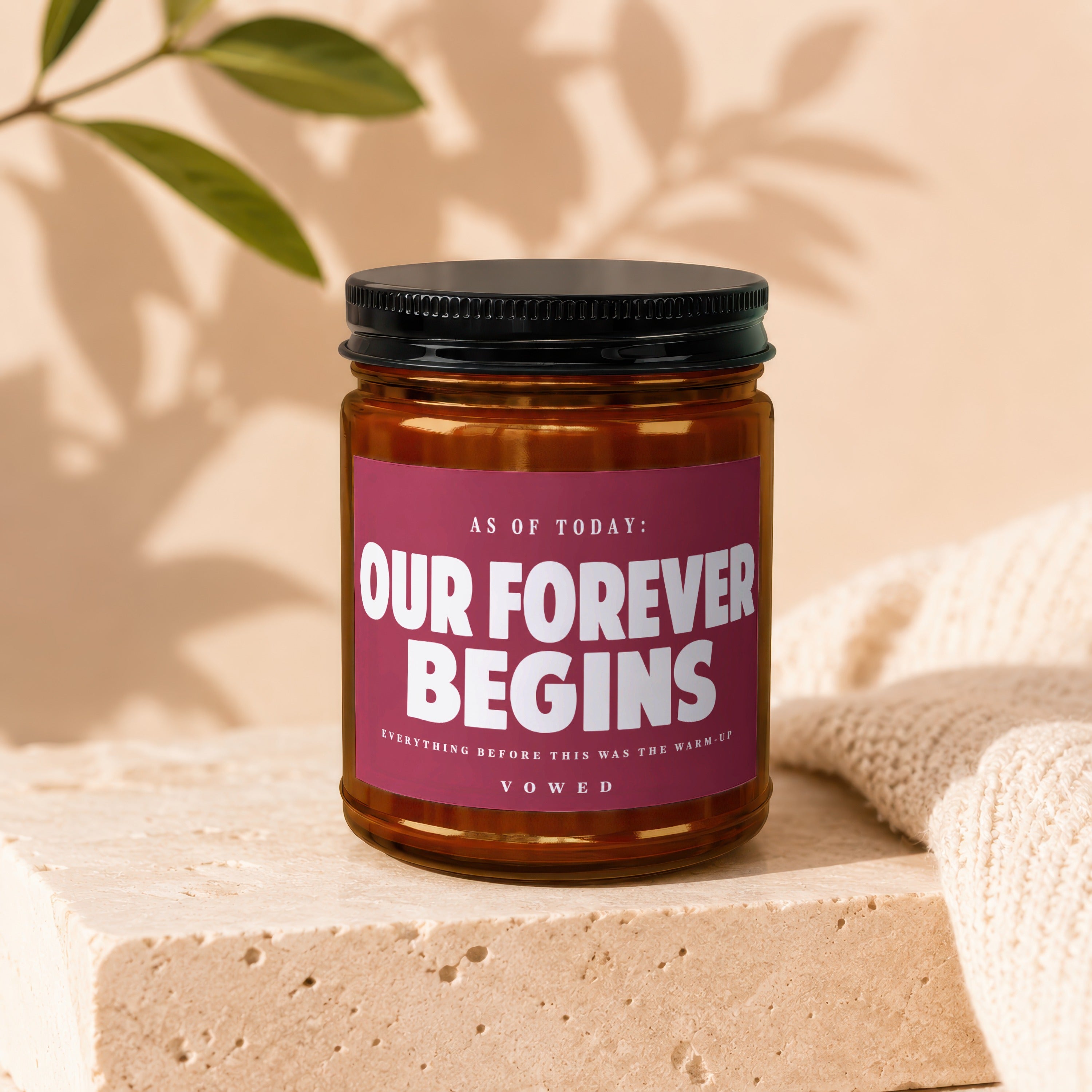 Glass jar candle with "Our Forever Begins" label, celebrating a vow.