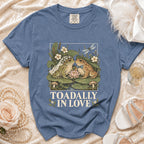 Blue t-shirt with cartoon frogs in wedding attire and text "TOADALLY IN LOVE".