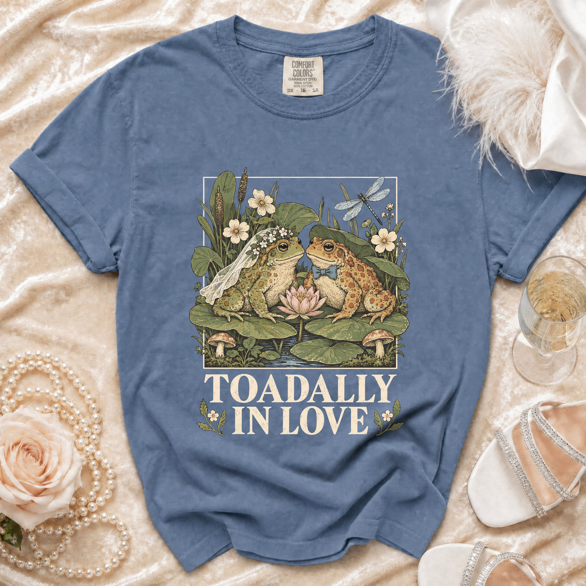 Blue t-shirt with cartoon frogs in wedding attire and text "TOADALLY IN LOVE".
