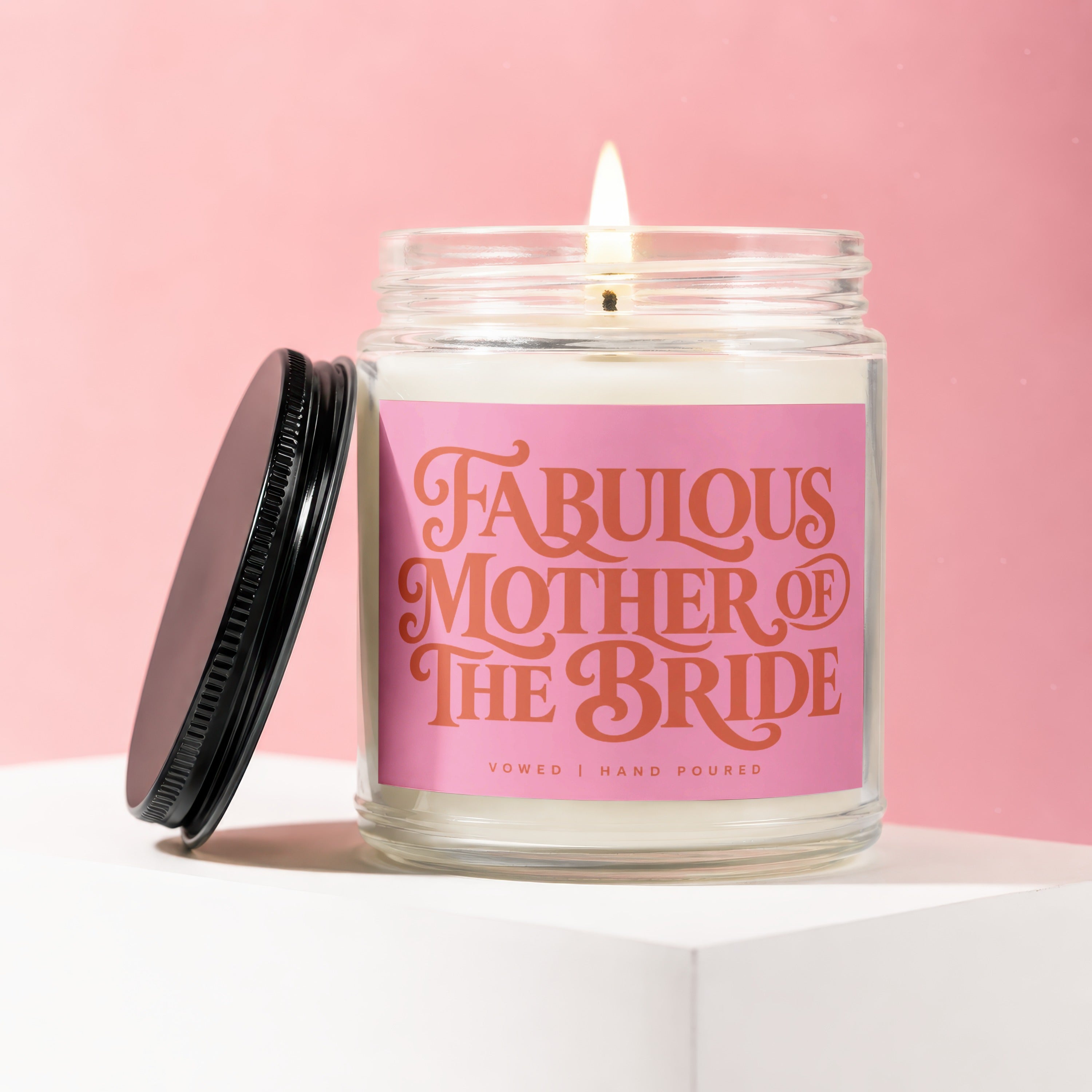 Jar candle with pink label reading "Fabulous Mother of The Bride" on a pink background.
