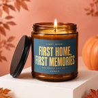 Amber glass candle with lit flame, label reads "Light When: First Home, First Memories".