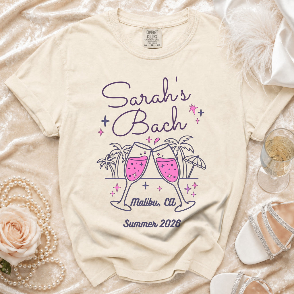 Cream t-shirt with "Sarah's Bach Malibu, Ca Summer 2026" and champagne glasses.